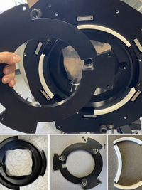 Black segmented mechanical rings and white curved inserts, some assembled, some individual components on display.