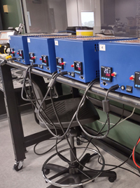 Four blue rectangular devices display '20.C' on a lab workbench with connecting cables.
