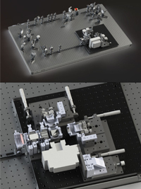 Complex optical experiment with numerous silver and white components arranged on a black breadboard. Red light present.